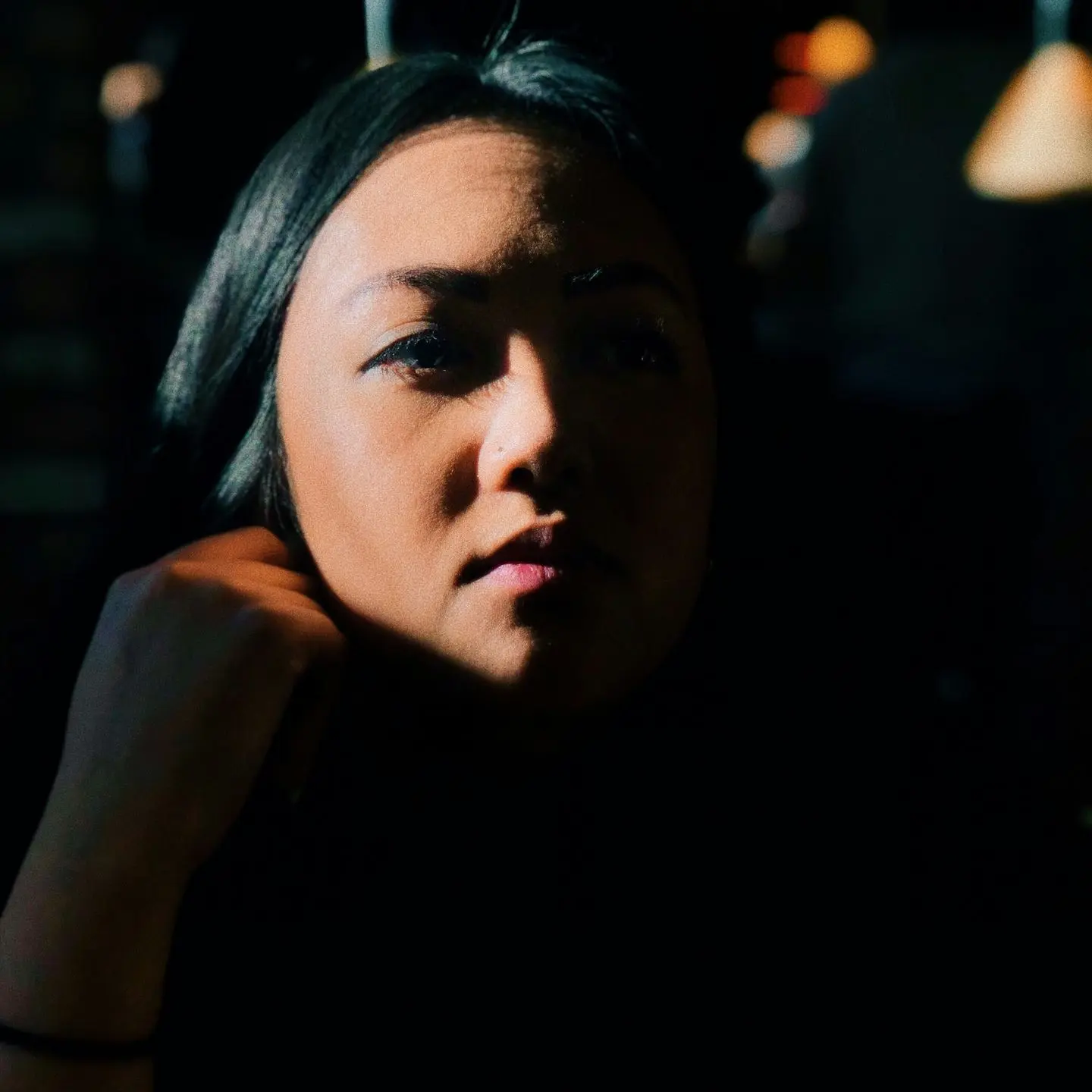 a woman sitting down with her hand on her shoulder